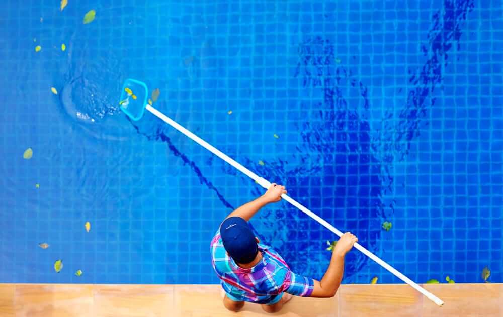 Birdseye view of man cleaning pool - Swimming Pool Maintenance Tips